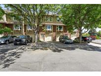 Charming townhome with brick facade, mature trees, garages, and convenient parking at 3300 W Florida Ave # 117, Denver, CO 80219
