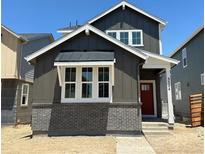 Charming two-story home with gray siding, brick foundation, and a vibrant red front door at 3324 N Catawba Way, Aurora, CO 80019