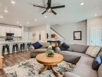 Cozy living room featuring hardwood floors, a ceiling fan, and comfortable seating at 11294 Bella Vita Dr, Broomfield, CO 80020