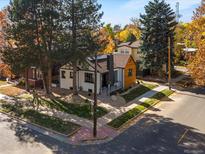 Charming home featuring a black-and-white exterior, landscaping, mature trees, and a welcoming walkway at 1640 E Virginia Ave, Denver, CO 80209