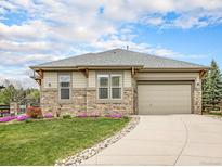Charming single Gathering home with beautiful stone accents, a well-manicured lawn and a two car garage at 19379 W 57Th Pl, Golden, CO 80403