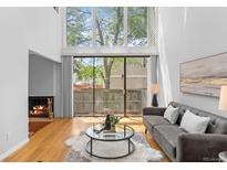 Bright living room with large windows, fireplace, and modern decor at 1050 S Monaco Pkwy # 68, Denver, CO 80224