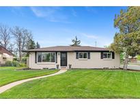 Charming home featuring a manicured lawn, updated windows and a paved walkway leading to the front door at 9790 E 5Th Ave, Aurora, CO 80010