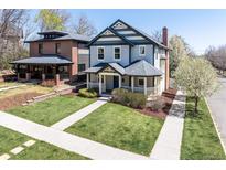 Charming two-story home with inviting front porch, manicured lawn, and beautiful landscaping at 3504 Newton St, Denver, CO 80211