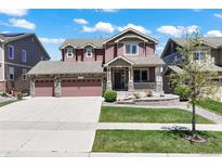 Charming two-story home with a three-car garage, covered porch, and well-maintained front yard at 20855 Park Hollow Dr, Parker, CO 80138