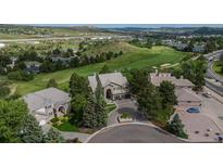 Stunning aerial view of a luxurious home on a lush golf course with mature trees and a circular driveway at 171 October Pl, Castle Rock, CO 80104
