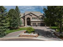 Stately stone and stucco home with circular driveway and mature landscaping at 171 October Pl, Castle Rock, CO 80104