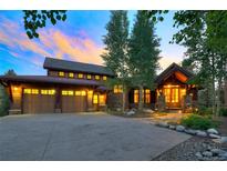 Inviting front exterior showcasing a three-car garage and charming architectural details at sunset at 805 Highfield Trl, Breckenridge, CO 80424
