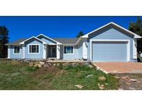 Charming light blue home with an attached garage and well-maintained lawn in a peaceful neighborhood at 40477 Ferns Rd, Elizabeth, CO 80107