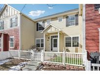 Charming home with a white picket fence, inviting front porch, and beautiful curb appeal at 1492 Red Cliff Way, Castle Rock, CO 80109