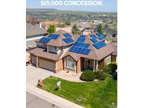 Inviting two-story home featuring a well-maintained lawn and solar panels at 58 Rogers Ct, Golden, CO 80401