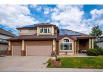 Attractive two-story home featuring a two-car garage, brick accents, lush lawn, and solar panels at 58 Rogers Ct, Golden, CO 80401
