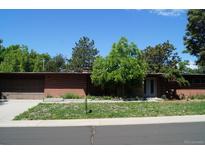 Single story brick home with a garage and a yard, under a sunny blue sky at 6775 S Sherman St, Centennial, CO 80122