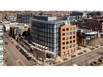 Modern, multi-story building with a curved facade, showcasing contemporary architecture in an urban setting near shops and businesses at 100 Detroit St # 103, Denver, CO 80206