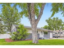 Charming home featuring a gray brick facade and a well-manicured lawn at 5150 W Colgate Pl, Denver, CO 80236