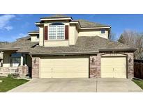 Lovely two-story home featuring a three-car garage and brick and siding exterior at 6459 S Queen Way, Littleton, CO 80127