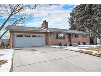 Charming single-story brick home with a two-car garage and a well-maintained front yard with winter landscaping at 8094 E Kenyon Pl, Denver, CO 80237