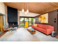 Inviting living room features a stone fireplace, floor-to-ceiling windows, and a cozy seating area at 3650 Chimayo Rd, Littleton, CO 80123