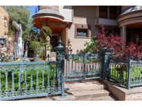 Charming home with a blue iron gate, landscaped garden, and a turret-style covered entryway at 1022 N Pearl St # 101, Denver, CO 80203
