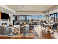 Modern living room featuring a fireplace, city views, and an open floor plan with hardwood floors at 1133 14Th St # 3320, Denver, CO 80202