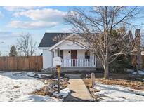 Charming white bungalow with a red door and porch at 1305 Tamarac St, Denver, CO 80220