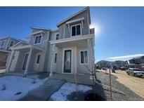 Two-story townhome with gray siding, stone accents, and a covered entryway at 22811 E Stanford Ln # A, Aurora, CO 80015