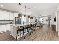 Modern kitchen with granite countertops, stainless steel appliances, and a breakfast bar with pendant lighting at 21893 E Tufts Cir, Aurora, CO 80015