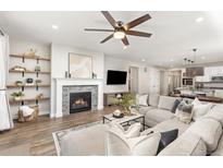 Bright living room features a modern fireplace, open shelving, and lots of comfortable seating at 21893 E Tufts Cir, Aurora, CO 80015