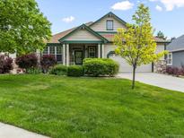 Beautiful single-Gathering home featuring a well-maintained lawn, lovely landscaping, and attached garage at 1836 S Kendall Ct, Lakewood, CO 80232
