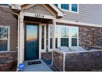 Charming townhome featuring a covered front entry, stone accents, and well-maintained landscaping at 12714 Leyden St # C, Thornton, CO 80602