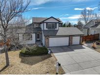 Charming two-story home featuring a three car garage and well maintained front yard and stone accents at 7036 Orion Ln, Arvada, CO 80007