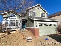 Two-story house with green siding, attached garage, and landscaping at 10703 Jordan Ct, Parker, CO 80134