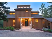 Charming home featuring covered entryway with decorative columns, dark green front door, and manicured landscaping at 207 Kelly E Rd, Boulder, CO 80302