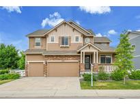 Beautiful two-story home featuring a stone and wood exterior with a large driveway and attached two-car garage at 20145 E Fair Ln, Centennial, CO 80016