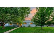 Charming single-story home with lush front yard and mature trees, beautiful landscaping at dusk at 3001 S Josephine St, Denver, CO 80210