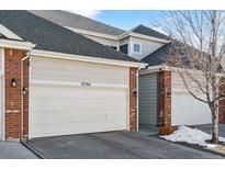 Garage door of townhome featuring red brick and neutral-colored siding with clear house numbers at 2796 Newport Cir, Castle Rock, CO 80104