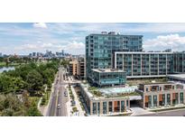Stunning aerial view of a modern condo complex with a rooftop pool and city skyline backdrop at 4200 W 17Th Ave # 619, Denver, CO 80204