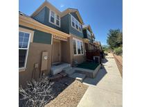 Two-story townhome with a front entrance, visible steps, and landscaped pathway on a sunny day at 12317 W Gould Ave, Littleton, CO 80127
