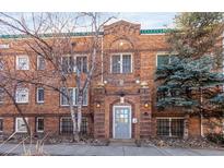 Charming brick building with an arched entryway and stone accents and a light gray front door at 1024 E 14Th Ave # 9, Denver, CO 80218