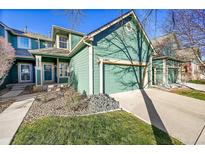 Inviting exterior of home featuring a two-car garage, manicured lawn and an inviting covered porch at 11803 W Stanford Dr, Morrison, CO 80465