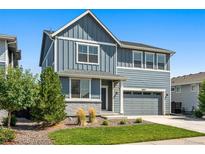 Charming two-story home with blue siding, gray accents, a well-maintained lawn and low maintenance landscaping at 26857 E Maple Ave, Aurora, CO 80018