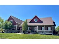 Charming two-story home with a welcoming front porch and a beautifully landscaped front yard at 690 Antelope Dr, Bennett, CO 80102
