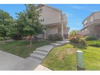 Inviting two-story home featuring a well-maintained lawn and concrete steps leading to the front door at 18096 E 104Th Way, Commerce City, CO 80022