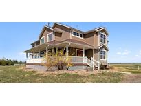 Charming two-story home featuring a welcoming front porch and well-maintained landscaping at 1212 N County Road 125, Bennett, CO 80102