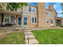 Charming townhouse featuring stone accents, lush lawn, and inviting front porch at 9615 W Chatfield Ave # C, Littleton, CO 80128