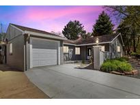 Charming home with gray brick, well-manicured landscaping, and a driveway leading to an attached garage at 4500 Zephyr St, Wheat Ridge, CO 80033