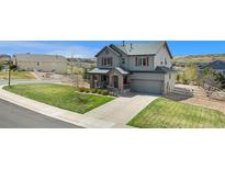 Charming two-story home with a well-manicured lawn, inviting front porch, and an attached two-car garage at 2516 Mountain Sky Dr, Castle Rock, CO 80104