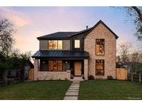 Stunning two-story home with brick and siding, a well-manicured lawn, and a charming walkway at 1680 S Humboldt St, Denver, CO 80210