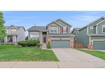 Charming two-story home with a well-maintained lawn and attached two car garage at 9869 Burberry Way, Highlands Ranch, CO 80129