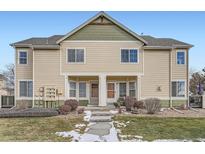 Tan two-story townhome with green accents, stone walkway, and landscaping at 15800 E 121St Ave # 3J, Brighton, CO 80603